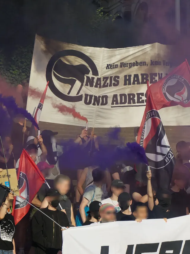 Zoom in den Mobshot, Antifa-Fahnen, Hochtranspi, Rauch